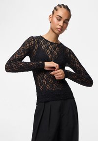 Musthave mustrõngastega must pitspays, millel on lilleline muster ja tekstureeritud viimistlus. Kere sobilik disain ümarate kaelustega. Sile siluett.