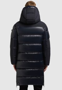 Abrigo de plumas navy con diseño acolchado, capucha ajustable y cremalleras laterales. Fabricado con material suave y brillante, con una silueta ajustada.