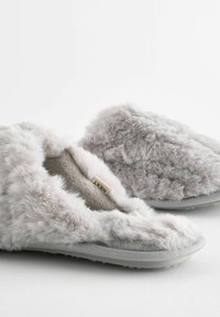 Faux furry slippers i blød grå med et åbent design, der har en luksuriøs tekstur og en fleksibel grå sål. Mærketiketten er synlig indeni.
