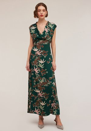 Green maxi dress with floral pattern in pink and brown, deep V-neck, cap sleeves, and a cinched waist. Textured fabric with flowy design.