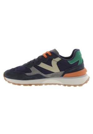 Marineblauwe en grijze suède sneakers met oranje veters, groene accenten, een crème tussenzool en een gestructureerde gumrubberen buitenzool. Heeft een gedurfd design.
