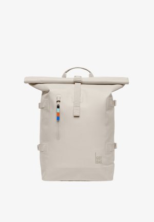 Beige roll-top rugzak met een frontvak met rits, kleurrijke trekker, verstelbare zijbanden en een "GOT BAG" logo aan de onderkant voor.
