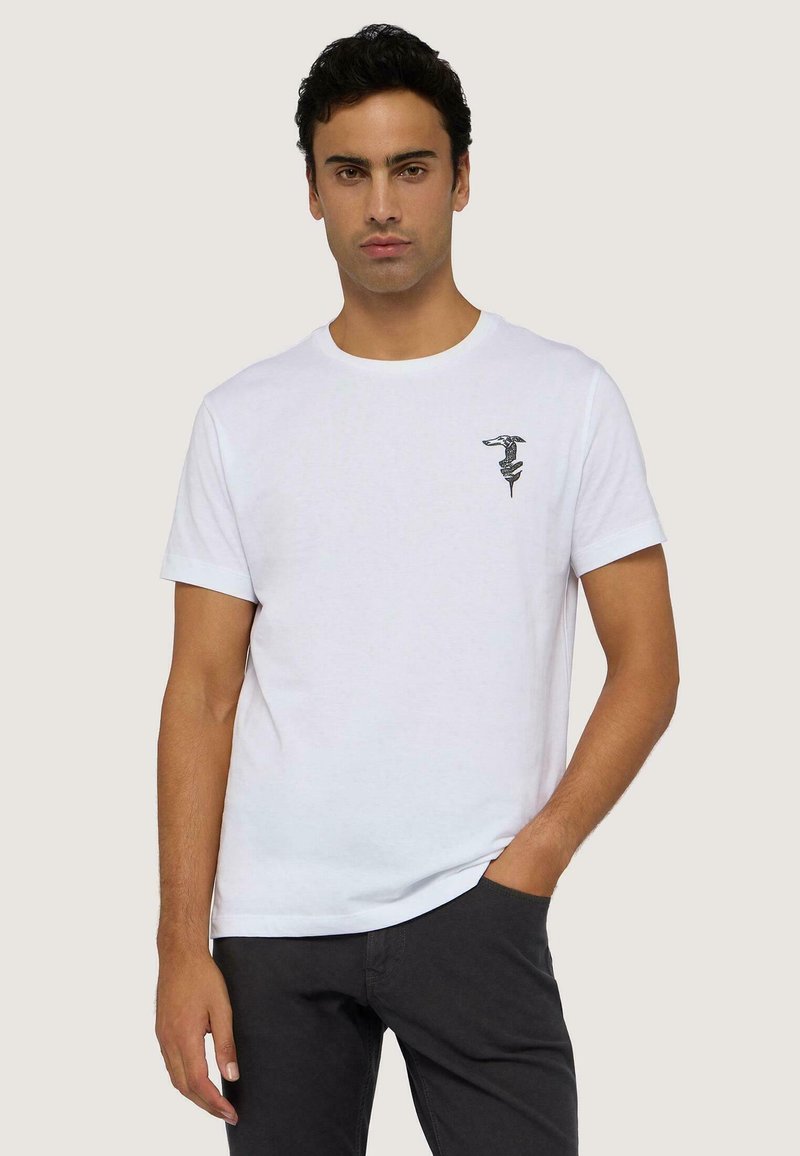 Bílý bavlněný tričko s kulatým výstřihem, krátkými rukávy a černým grafickým designem na levé straně hrudi. Volný střih, hladká textura.