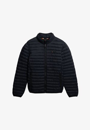 Marineblaue Steppjacke mit Reißverschluss, Stehkragen und horizontalem Steppmuster. Sie verfügt über Seitentaschen und ein Logopatch auf der Brust.
