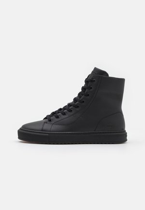 Czarny sneaker z wysoką cholewką z sznurówkami, gładką skórzaną cholewką, grubą gumową podeszwą i subtelnym tłoczonym logo z boku i na pięcie.