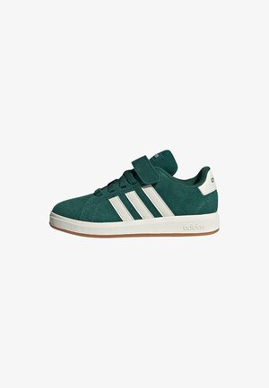 Zielony zamszowy sneaker Adidas z białymi paskami, paskiem na rzep, białą klapką na pięcie oraz gumową podeszwą, widok z boku.