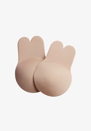 Coppette per reggiseno in silicone di colore beige morbido, di forma rotonda con una superficie liscia, dotate di un esclusivo bordo superiore a forma di cuore per un adattamento sicuro.