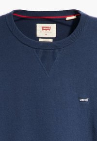 Marineblauwe sweatshirt met een geribbelde halslijn en schouderaccenten, voorzien van een klein wit Levi's logo op de borst. Standaard pasvorm ontwerp.