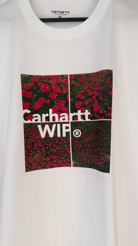 Biela bavlnená tričko s obdĺžnikovou kvetinovou grafikou s červenými kvetmi na zelenom pozadí a textom "Carhartt WIP" nižšie.