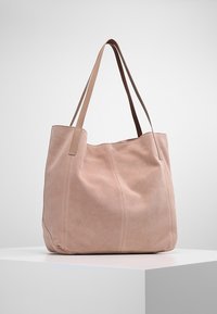 Rosa suedes tote-väska med två läderremmar, med vertikala sömmar och ett rymligt, mjukt inre. Enkel, odekorerad design.