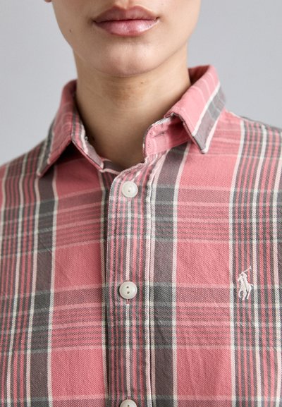 Camisa de cuadros en rojo y gris, de tela de algodón, con cuello abotonado, botones blancos, presenta un logo bordado en el pecho, ajuste estructurado.