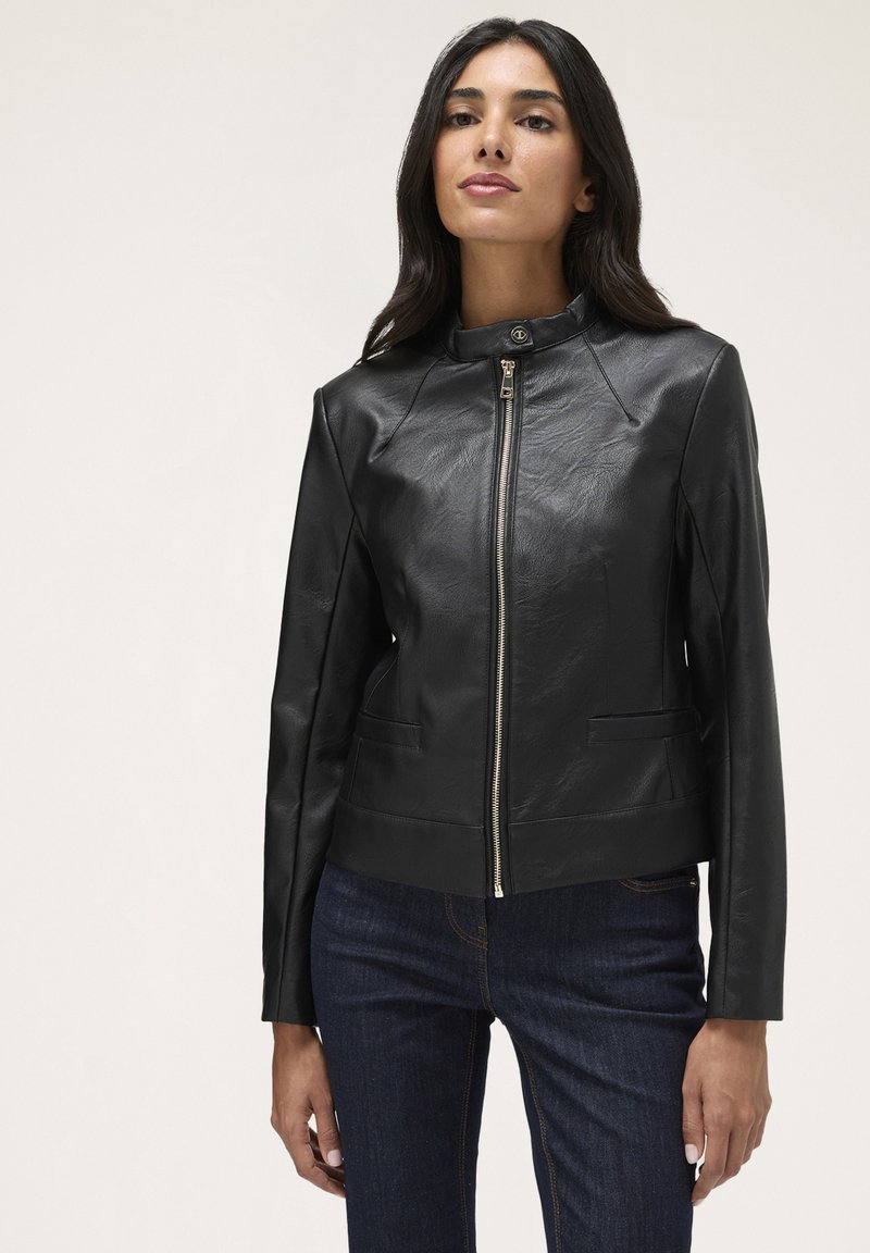 Giubbotto in finta pelle nera con colletto alto, chiusura frontale con zip e due tasche laterali. Presenta un design corto e dettagli cuciti.