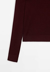 Pull bordeaux foncé à manches longues avec poignets et ourlet côtelés, présenté sur fond blanc.