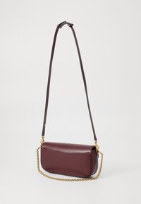 Bordeauxrote Lederhandtasche mit glatter Textur, geschwungener Form, abnehmbarem braunen Tragegurt und goldenen Kettenakzenten. Einfaches Design ohne sichtbare Hardware.