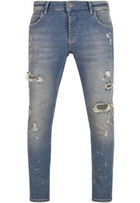 Sinine teksapükste slim fit mudel, millel on mitmed kulunud plaastrid ja kulumisjäljed, heledam pesu, viis taskut ja nööbi sulgemine.