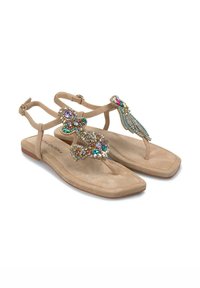 Sandali in suede beige con decorazioni gioiello ornate in più colori, dotati di suola piatta e cinturini alla caviglia regolabili.
