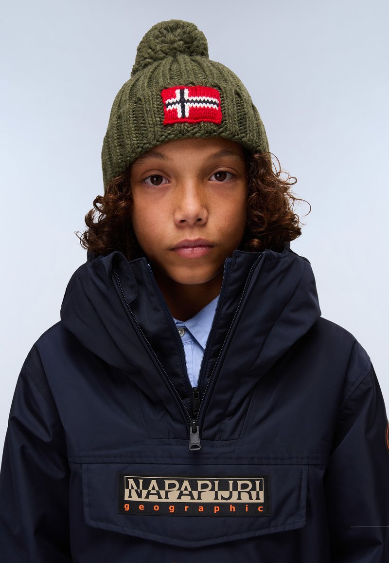 Gorrón de punto verde oliva con pompón y parche de la bandera noruega roja; chaqueta impermeable azul marino con bolsillo con cremallera y logo de la marca.