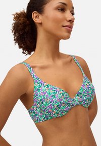 Sujeción con aros de patrón floral en verde, púrpura y rosa. Presenta tirantes anchos y una textura suave con un detalle de nudo central.
