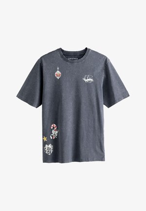 Camiseta de manga corta en gris oscuro, hecha de algodón, con gráficos temáticos navideños que incluyen adornos, un bastón de caramelo y un regalo.