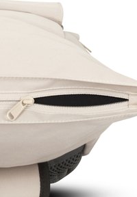 Sac en tissu beige avec fermeture éclair, doté d'un fond texturé et d'une doublure intérieure noire contrastante. Souligné par des coutures durables.