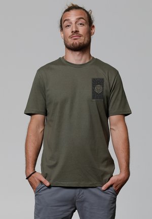 Olijfgroen t-shirt met korte mouwen van katoen, voorzien van een zwarte grafische print op de linkerkant van de borst. Zachte textuur met een reguliere pasvorm.