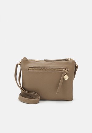 Sac à bandoulière synthétique marron avec une longue sangle, doté d'un compartiment zippé et d'une petite étiquette décorative avec un accent doré.