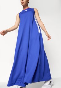 Blue sleeveless dress featuring a loose fit, made of soft fabric with red and white accents, and signature three stripes on the side.