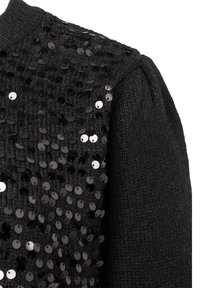 Schwarzer Strickstoff, der mit dicht aneinandergenähten, glänzenden schwarzen Pailletten bedeckt ist und die meisten Oberflächenbereiche einnimmt, mit Fokus auf den strukturierten Ärmel- und Schulterbereich.