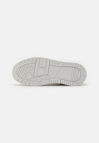 Semelle d'une chaussure taille 41 avec des motifs divers comprenant des cercles, des rectangles, des zigzags et des lignes de couleur gris clair.