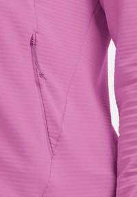 Strakke hoodie van felroze stof, met subtiele verticale ribbels, een met rits afsluitbare zak aan de zijkant en naadloze schouderconstructie.