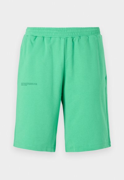 Grüne Baumwollshorts mit elastischem Bund, knielanger Schnitt und bedrucktem Textdetail auf der linken Seite. Glatte Textur, einfaches Design.