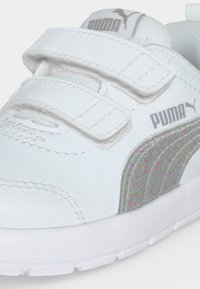 Λευκό αθλητικό παπούτσι Puma με δύο λουράκια με βέλκρο, γκρι λογότυπο Puma και γκρι πλευρική ρίγα με στίγματα, σε κοντινή λήψη.