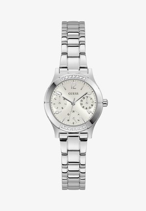 Montre-bracelet en métal argenté avec un cadran blanc, trois sous-cadrans, accents en cristal sur la lunette, et le logo "GUESS" au centre.