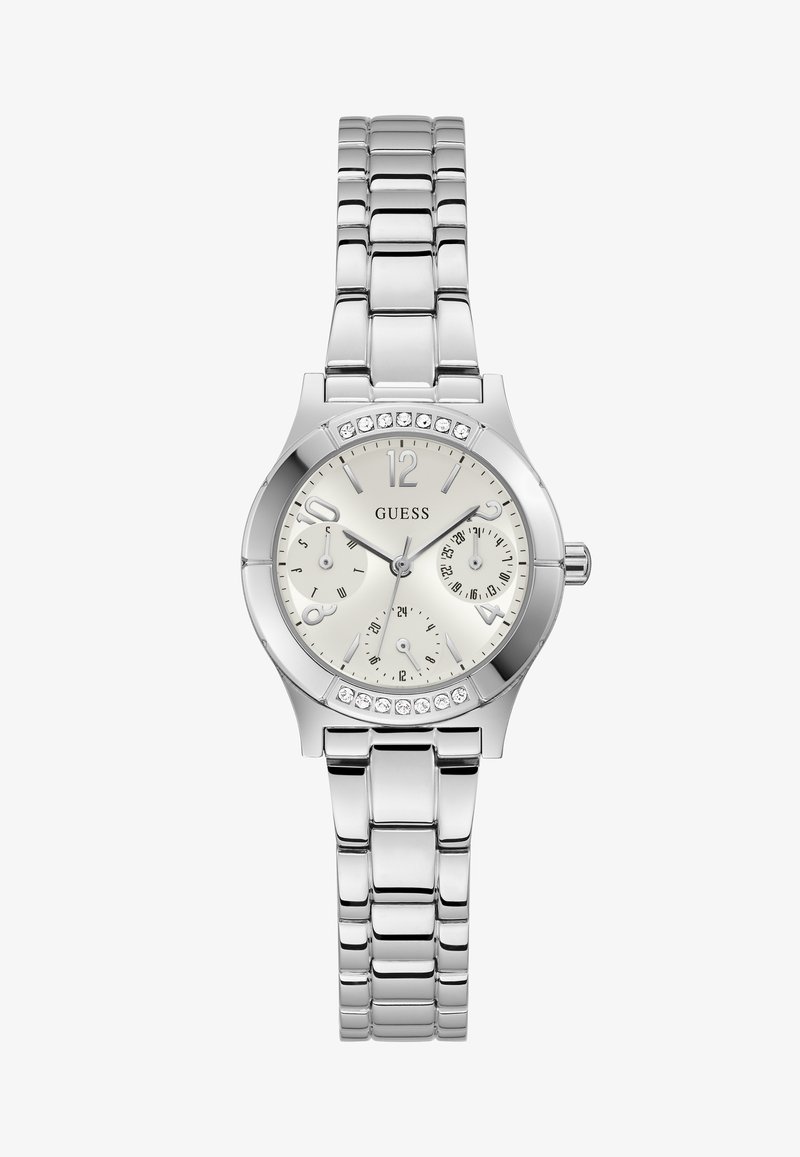 Montre-bracelet en métal argenté avec un cadran blanc, trois sous-cadrans, accents en cristal sur la lunette, et le logo "GUESS" au centre.