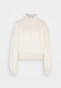 Sudadera corta color beige claro con cuello alto y media cremallera. Presenta puños acanalados y una textura suave y lisa. Diseño sencillo.