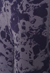 Legginsy z mieszanki tkanin, z wirującym, abstrakcyjnym wzorem w ciemnoniebieskich i szarych odcieniach, z widocznymi detalami szwów.