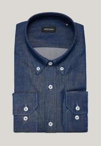 Granatowa koszula dżinsowa z zapięciem na guziki, kołnierzykiem typu wskazującego i długimi rękawami z mankietami. Metka z napisem "PRÓCHNIK". Gładka faktura.