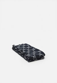 Marineblauwe, patroontekstiel, gevouwen met witte geometrische ontwerpen, voorzien van franjes, gemaakt van lichtgewicht stof.