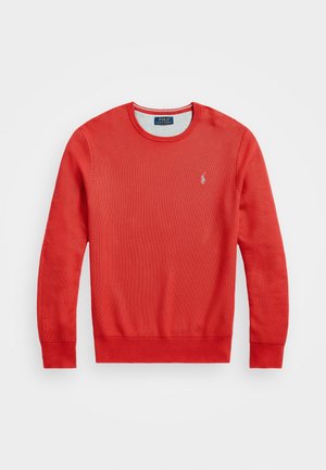 Pull-over rouge à manches longues avec un col rond, tricot texturé, poignets et ourlet côtelés, et petit logo Polo Ralph Lauren brodé sur la poitrine.