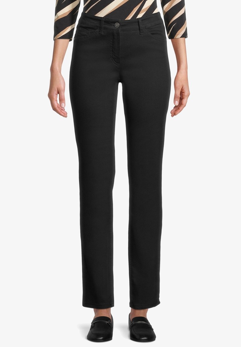 Svarta raka jeans i stretchig denim. Har framfickor och knappstängning. Bärs med en mönstrad topp och svarta skor.