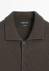Tmavě hnědý vlněný cardigan s žebrovaným límcem, dvěma černými knoflíky a značkovou etiketou Massimo Dutti uvnitř límce.