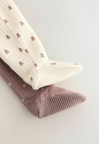 To par såler; en i creme med teddy-bjørn mønster, den anden i mauve. Begge har strukturerede såler og kviltede designs.