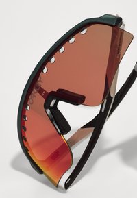 Sonnenbrille mit einem schwarzen Rahmen und roten Verlaufslinsen. Verfügt über ein großes, gebogenes Linsendesign und kleine Löcher entlang der Oberseite zur Belüftung.