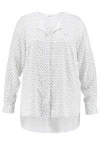 Chemise blanche à manches longues avec un col en V et un ourlet droit. Caractérisée par un motif de lignes verticales noires et un tissu doux et léger.