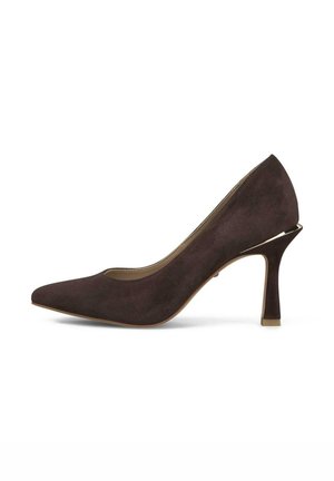 Donkerbruine suède pump met hoge hak, puntige neus en uitlopende hak op witte achtergrond.