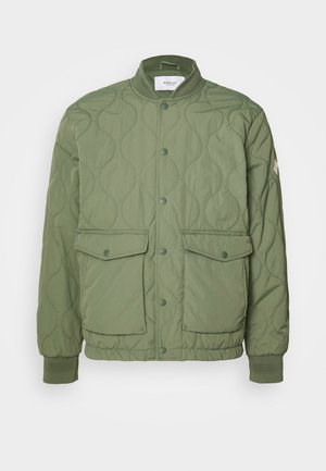Green quilted jacket featuring a round collar, snap buttons, two front pockets, and ribbed cuffs, made from lightweight material.