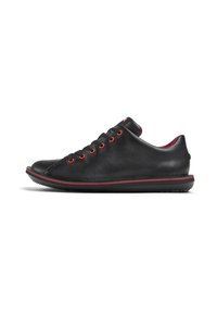 Sneaker in pelle nera con occhielli e rifiniture rosse, dotate di punta arrotondata e tomaia testurizzata, montate su una suola in gomma nera.