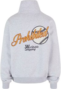 Grå genser med høy krage, med teksten "Forbudt" i oransje og et baseball-graphic. Inkluderer "Verdensomspennende frakt" i svart.