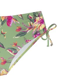 Bas de bikini floral avec un fond vert, des fleurs tropicales roses et jaunes, des liens sur les côtés et une texture lisse avec des coutures visibles.
