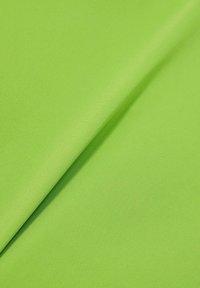 Fényes zöld anyag, sima, kissé texturált felülettel, puha, rugalmas összetétellel, látható minták vagy díszítések nélkül.